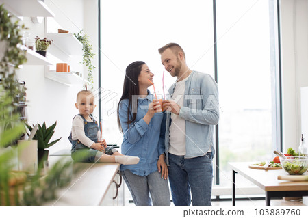 Parents and child spending time together in kitchen Parents and child spending time together in kitchen 103889760