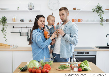 Happy family trying homemade fresh juice on sunday morning Happy family trying homemade fresh juice on sunday morning 103889774