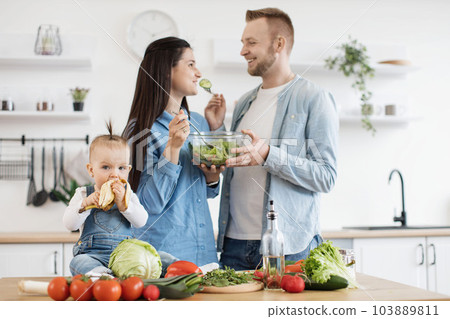 Parents and kid enjoying healthy food in modern kitchen 103889811