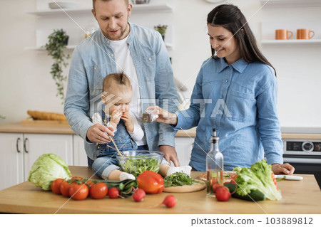 Young family cooking natural balanced food together indoors 103889812