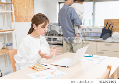 A wife who works remotely with her husband sharing babysitting 103893405