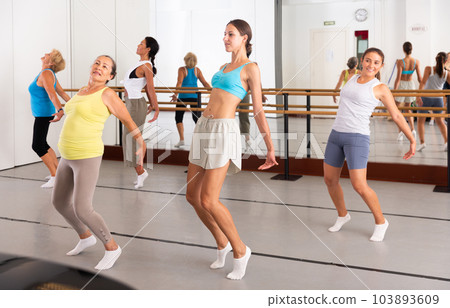 Group of active women practicing energetic dance in a studio 103893609