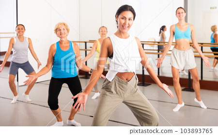 Positive asian woman practices energetic swing in a dance studio 103893765