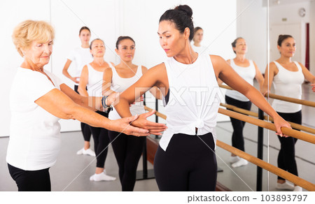 Women training ballet moves with trainer 103893797
