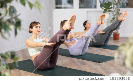 Group of active women practice various yoga poses 103893938