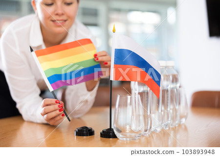 Unrecognizable girl sets midget flags of Russia and LGBT before international negotiations Unrecognizable girl sets midget flags of Russia and LGBT before international negotiations 103893948