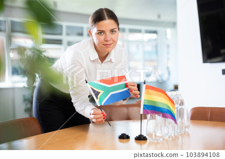 Woman setting South African and LGBT community flags on negotiating table 103894108