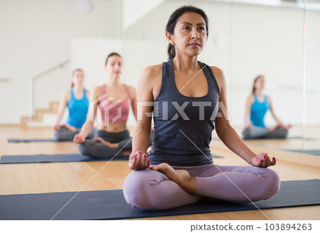Portrait of latin american woman making yoga meditation in lotus pose Portrait of latin american woman making yoga meditation in lotus pose 103894263