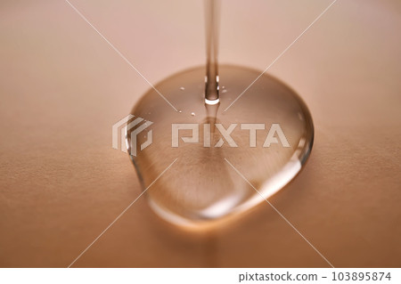 A juicy drop of gel on a beige background. A juicy drop of gel on a beige background. 103895874