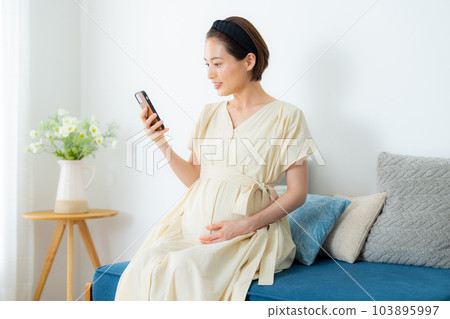 Pregnant woman living room 103895997