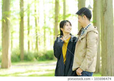 Portrait of man and woman standing in forest 103896474