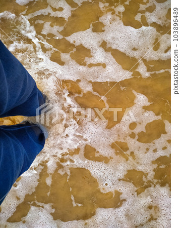 Person standing in the sea wave Person standing in the sea wave 103896489