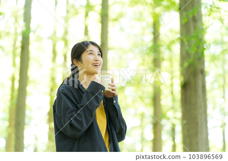 Woman drinking coffee in nature Woman drinking coffee in nature 103896569