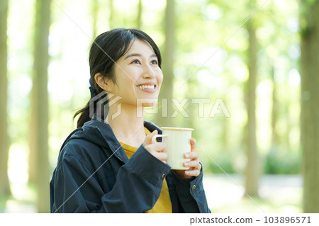 Woman drinking coffee in nature Woman drinking coffee in nature 103896571