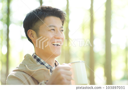 Woman drinking coffee in nature Woman drinking coffee in nature 103897031
