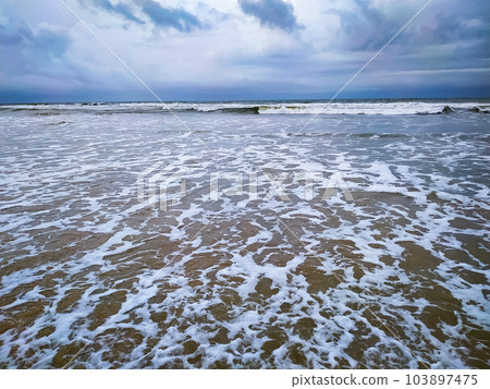 Clouds over beautiful waves on the beach Clouds over beautiful waves on the beach 103897475