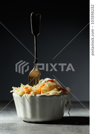 Bowl of sauerkraut with a carrot. Bowl of sauerkraut with a carrot. 103898282