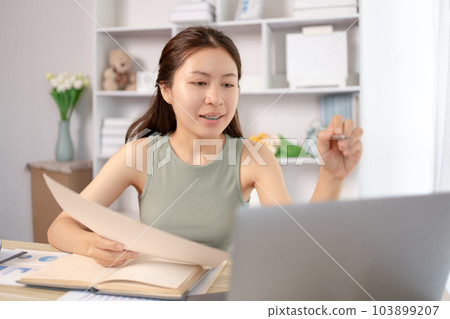 Young Asian female student watching teacher's live performance or video call on laptop in classroom at home, Conversations with teachers and classmates, Online learning, Study at your own home. Young Asian female student watching teacher's live performance or video call on laptop in classroom at home, Conversations with teachers and classmates, Online learning, Study at your own home. 103899207