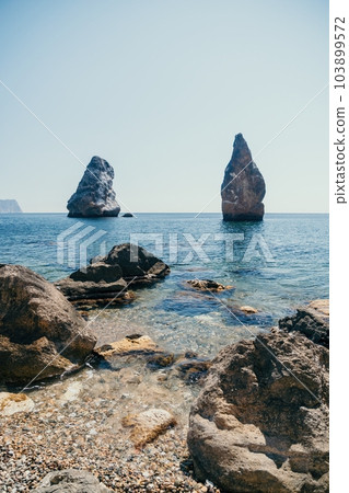 Aerial view from above on calm azure sea and volcanic rocky shores. Small waves on water surface in motion blur. Nature summer ocean sea beach background. Nobody. Holiday, vacation and travel concept 103899572