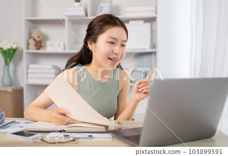 Asian student chatting or exchanging knowledge through laptop video call, Education through wireless education system, Conversations with teachers and classmates, Online learning, Study at home. 103899591