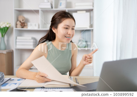 Asian student chatting or exchanging knowledge through laptop video call, Education through wireless education system, Conversations with teachers and classmates, Online learning, Study at home. 103899592