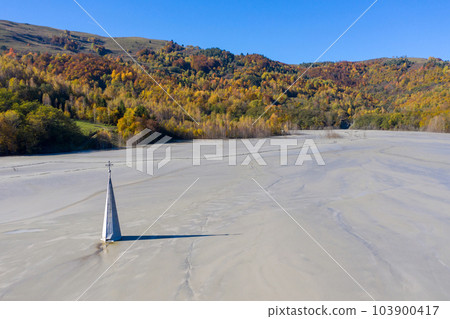 Aerial apocalyptic scene, church tower with cross buried under mud and toxic copper mining residuals 103900417