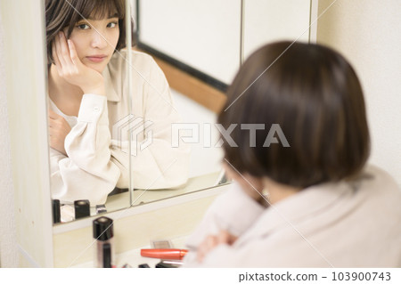 Mirror portrait of woman applying makeup 103900743