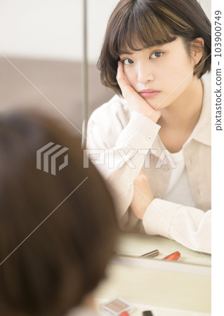 Mirror portrait of woman applying makeup 103900749