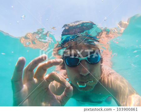 Underwater view of a man swimming in the sea Underwater view of a man swimming in the sea 103900861