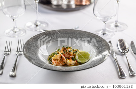 Grilled shrimps with chilli and garlic in a design plate on a set table 103901188