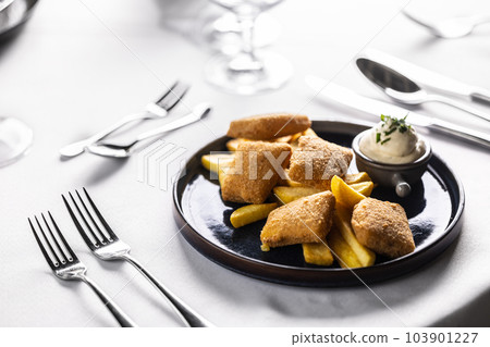 Breaded cheese pieces fried with french fries and served with mayonnaise 103901227