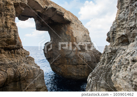 Wied il Mielah canyon, natural arch over the sea. Gozo, Malta 103901462