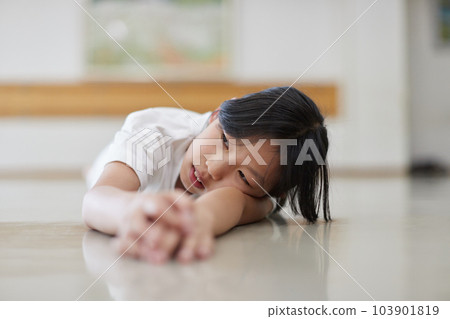 Elementary school girl practicing karate in the classroom 103901819