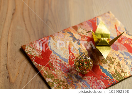 金色錦緞上的摺紙鶴和水引手球 103902598