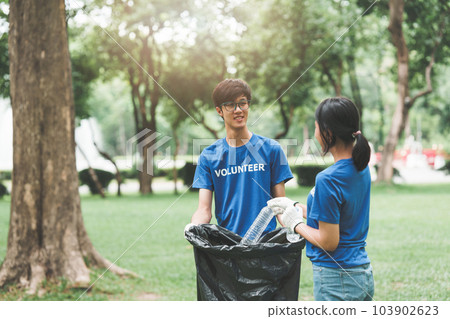 Young Asian Volunteers with garbage bags cleaning park area. Ecology, Charitable organization concept Young Asian Volunteers with garbage bags cleaning park area. Ecology, Charitable organization concept 103902623