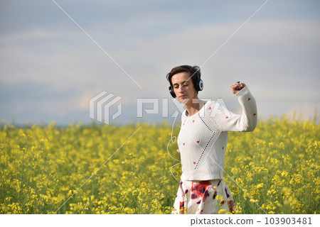 Caucasian girl listening to music with headphone in the outdoors 103903481