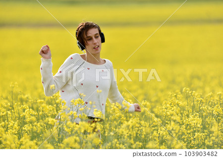Caucasian girl listening to music with headphone in the outdoors 103903482