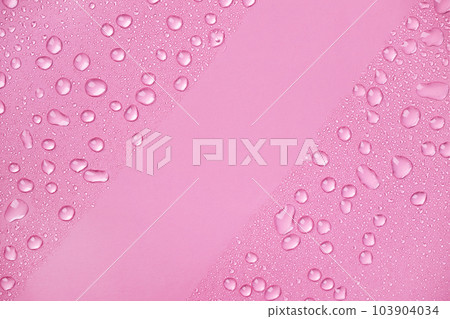 Water drops on pink background top view. Cosmetic moisturizing liquid drops of toner or hyaluronic serum, copy space. Water drops on pink background top view. Cosmetic moisturizing liquid drops of toner or hyaluronic serum, copy space. 103904034