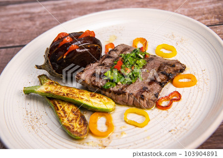 Grilled steak with chimichurri sauce and vegetables Grilled steak with chimichurri sauce and vegetables 103904891