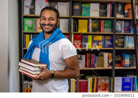 Dark-skinned man standing in the library Dark-skinned man standing in the library 103906011