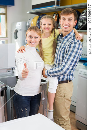 Parents with daughter in home appliance store Parents with daughter in home appliance store 103906637
