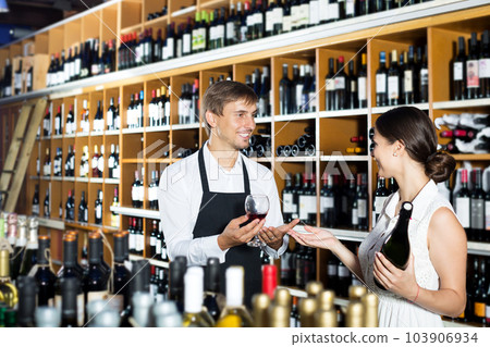 Seller in a wine house and visitor 103906934