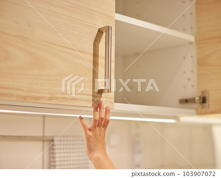 Child's hands searching for things from kitchen shelves at home Child's hands searching for things from kitchen shelves at home 103907072