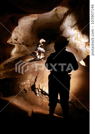 Spelunkers exploring a cave 103907146