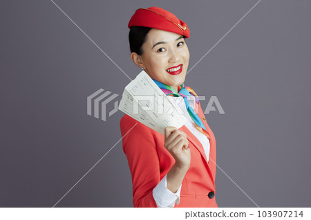 happy modern stewardess asian woman isolated on grey background happy modern stewardess asian woman isolated on grey background 103907214