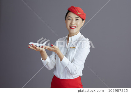 smiling flight attendant asian woman against gray smiling flight attendant asian woman against gray 103907225
