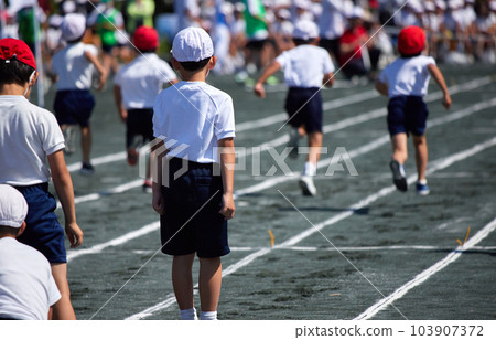 Back view of students running a short distance at an elementary school athletic meet 103907372
