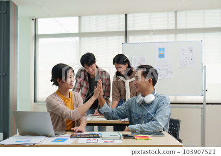 Team of ux developer and ui designer brainstorming interface wireframe design.Creative digital development agency 103907521