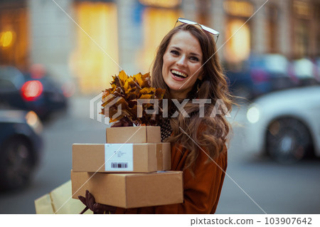 happy woman in orange trench coat 103907642