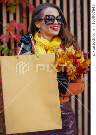 smiling trendy 40 years old woman in orange trench coat smiling trendy 40 years old woman in orange trench coat 103907649